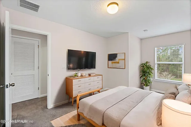 a bedroom with a bed and a flat screen tv