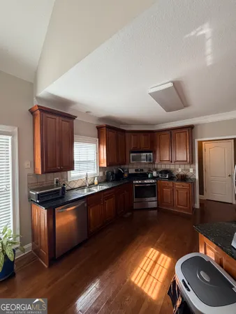 a kitchen with stainless steel appliances kitchen island granite countertop a stove a sink and a refrigerator