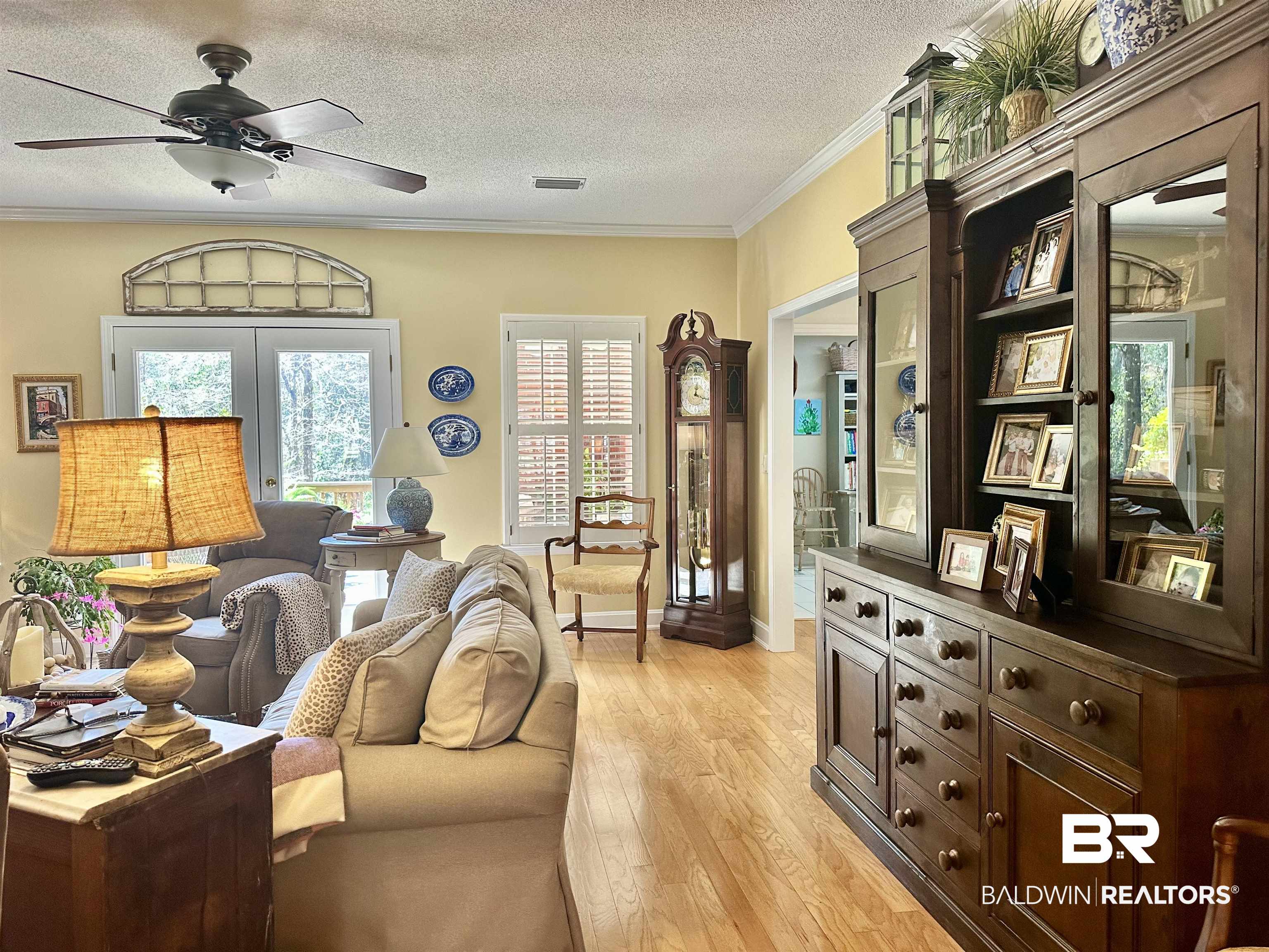 148 Brooks Boulevard Brewton, AL 36426 - Photo 7 of 45 Living room with visible vents, ceiling fan, ornamental molding, light wood-style floors, and a textured ceiling