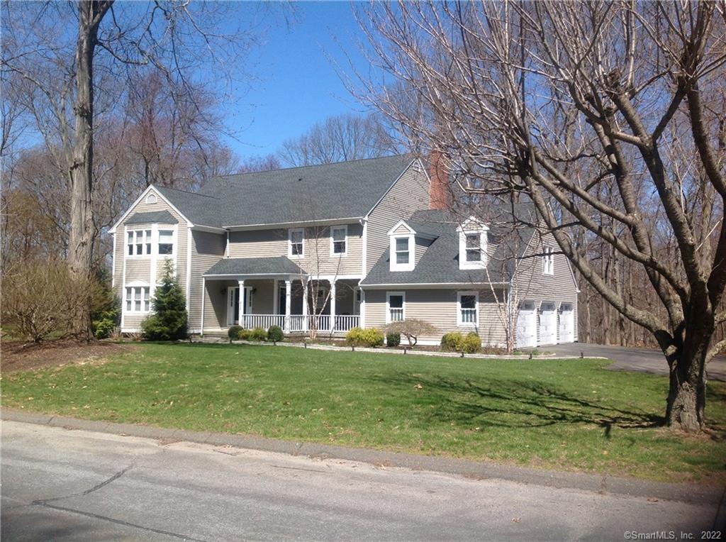 a front view of a house with a garden and trees
