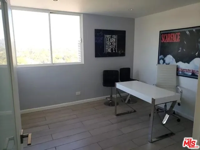 a view of a workspace with furniture and a window