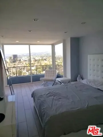 a bed sitting in a bedroom next to a large window