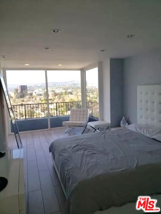 10501 Wilshire Boulevard, Unit 2103 Los Angeles, CA 90024 - Photo 13 of 19 a bed sitting in a bedroom next to a large window