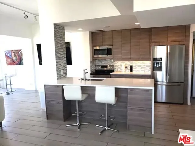 a kitchen with stainless steel appliances a refrigerator and a stove top oven