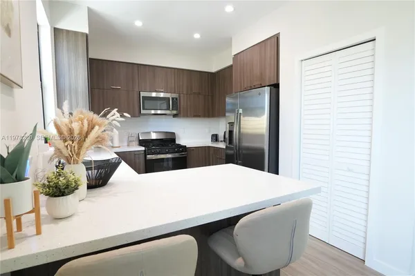 a kitchen with stainless steel appliances a refrigerator sink and cabinets