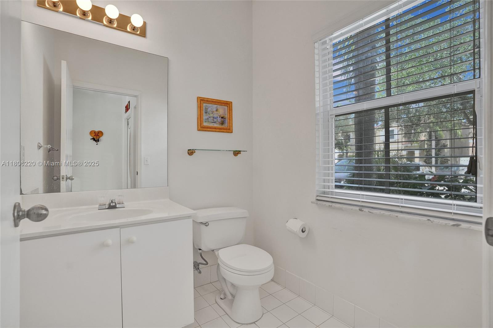 3910 Fern Forest Road Cooper City, FL 33026 - Photo 11 of 38 a bathroom with a toilet a sink and a large mirror