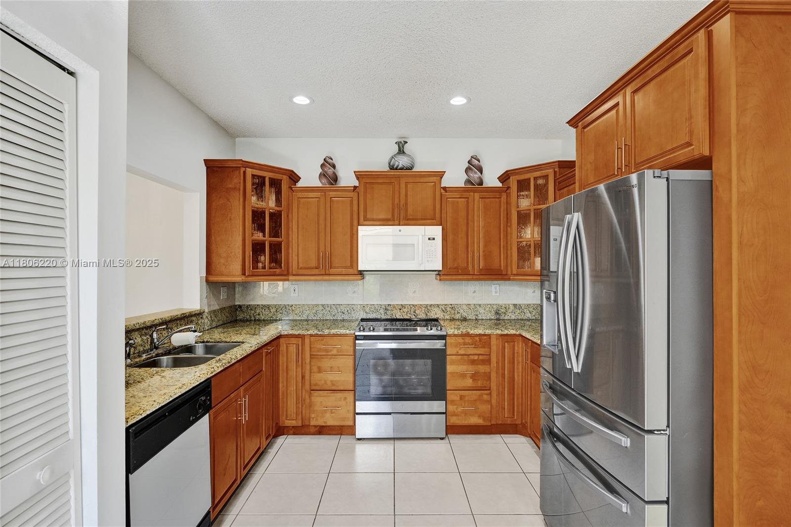 3910 Fern Forest Road Cooper City, FL 33026 - Photo 12 of 38 a kitchen with stainless steel appliances granite countertop a refrigerator and a stove