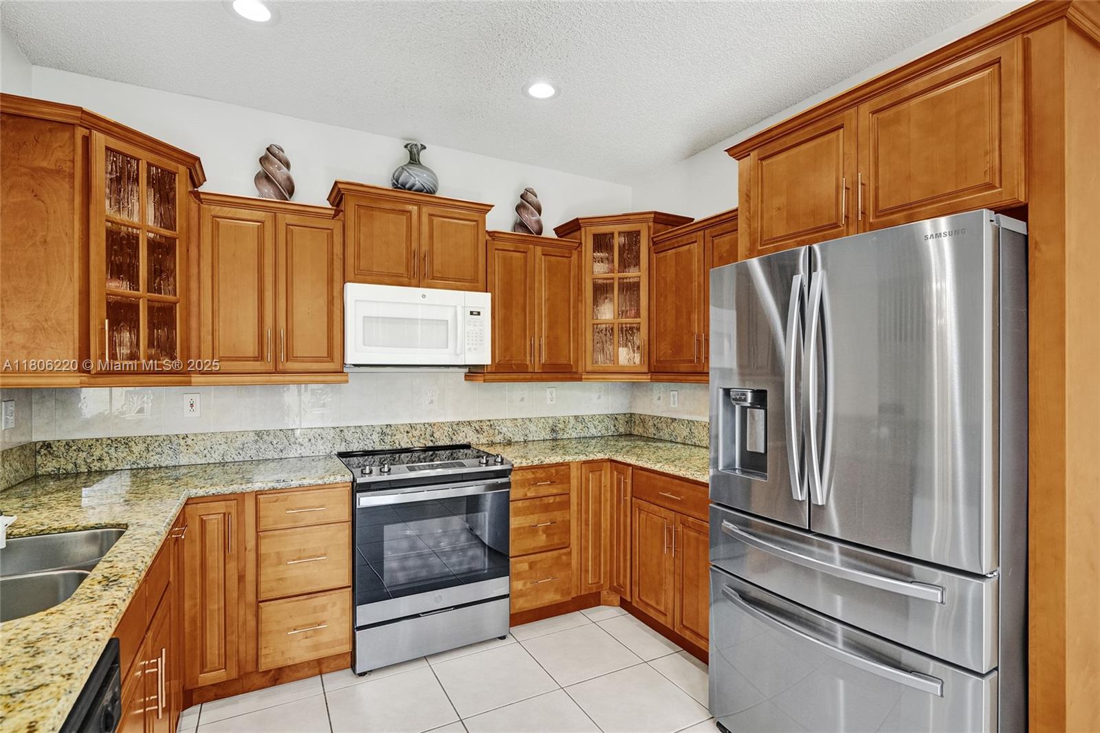 3910 Fern Forest Road Cooper City, FL 33026 - Photo 13 of 38 a kitchen with stainless steel appliances granite countertop a refrigerator and a sink