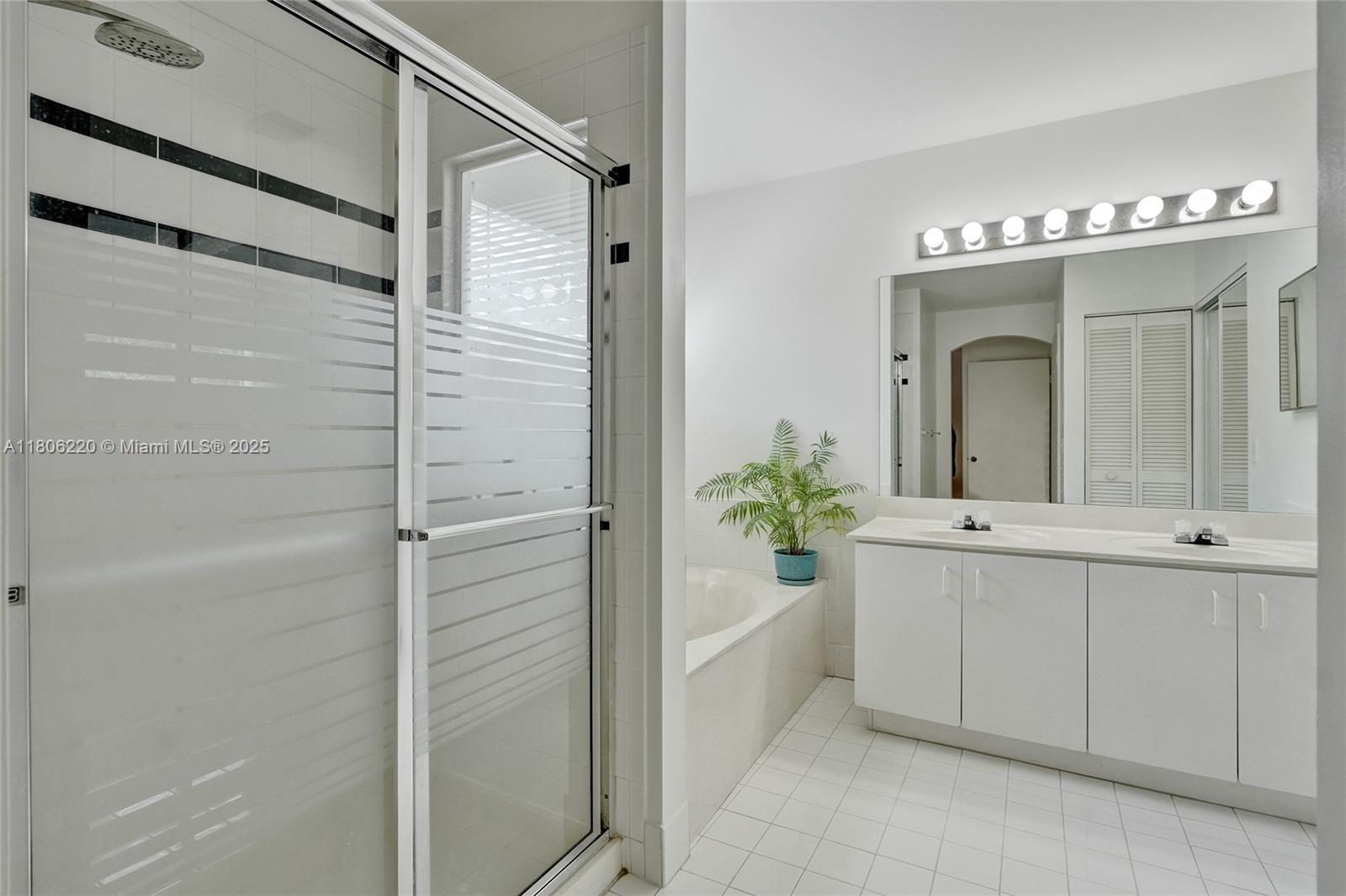 3910 Fern Forest Road Cooper City, FL 33026 - Photo 18 of 38 a bathroom with a tub shower and a mirror