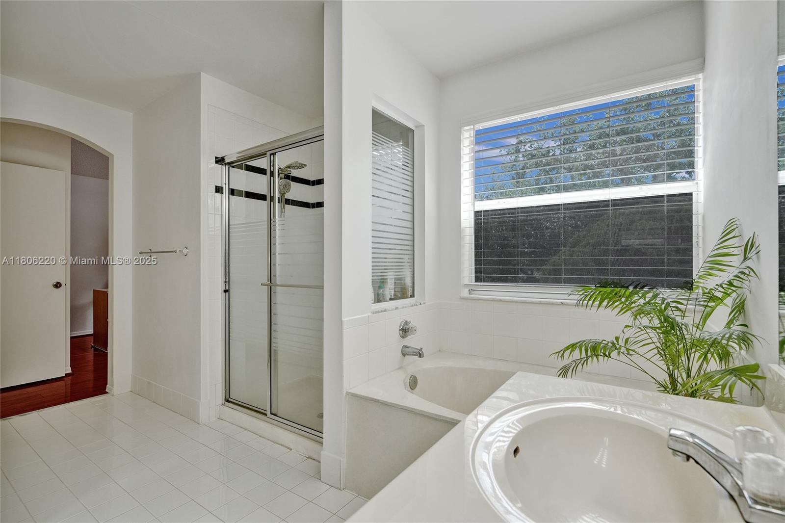 3910 Fern Forest Road Cooper City, FL 33026 - Photo 19 of 38 a bathroom with a granite countertop tub a sink and a large window