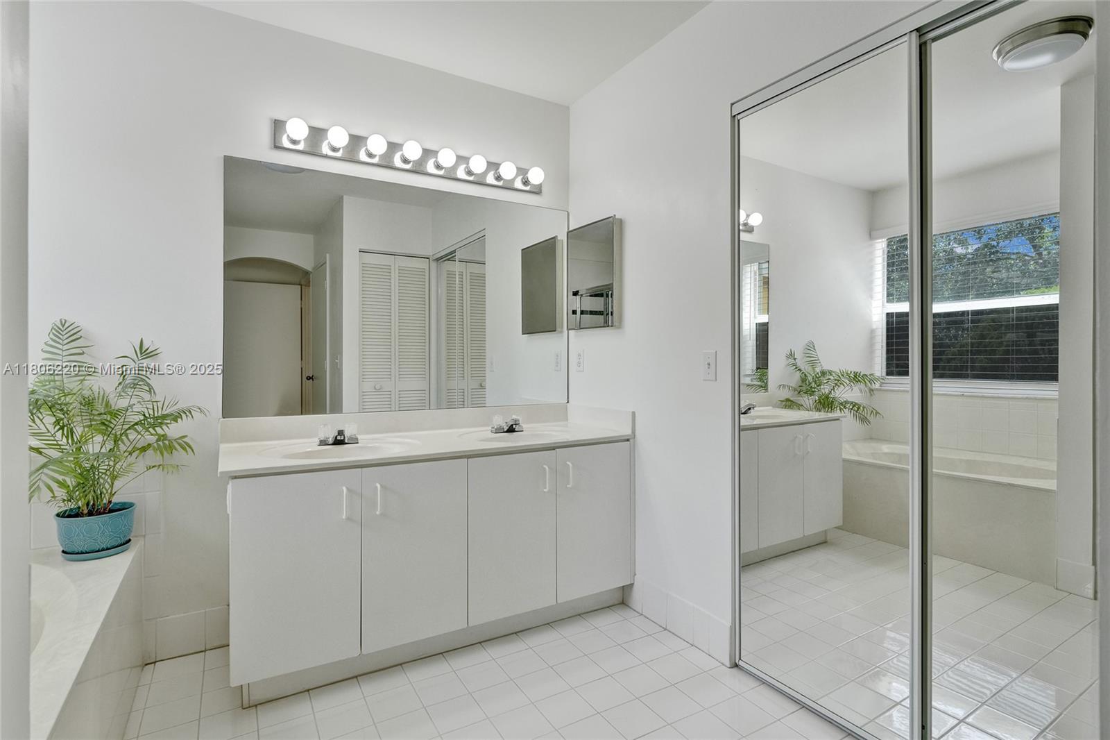 3910 Fern Forest Road Cooper City, FL 33026 - Photo 20 of 38 a bathroom with a double vanity sink mirror and shower