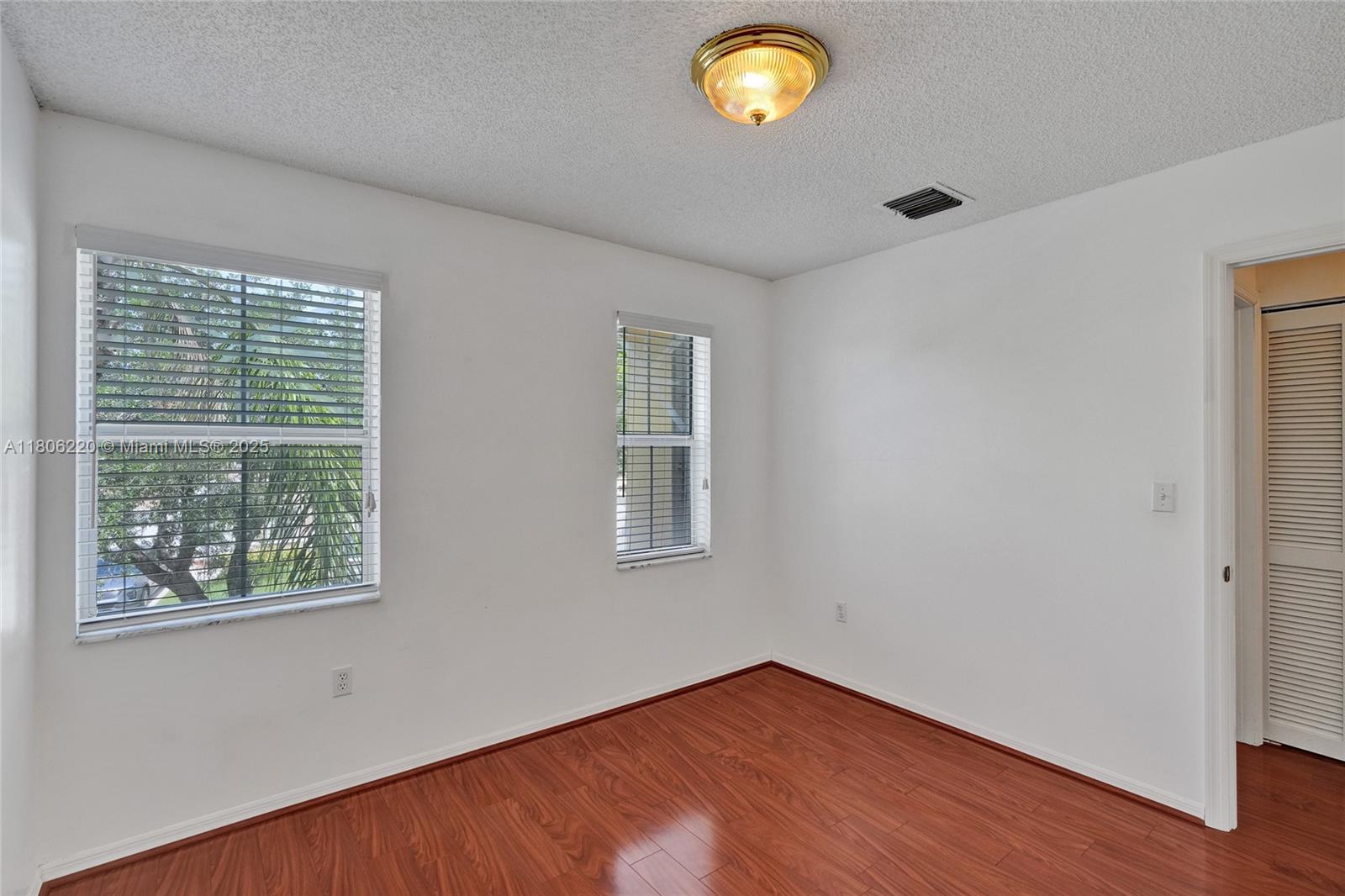 3910 Fern Forest Road Cooper City, FL 33026 - Photo 21 of 38 a view of an empty room with wooden floor and a window