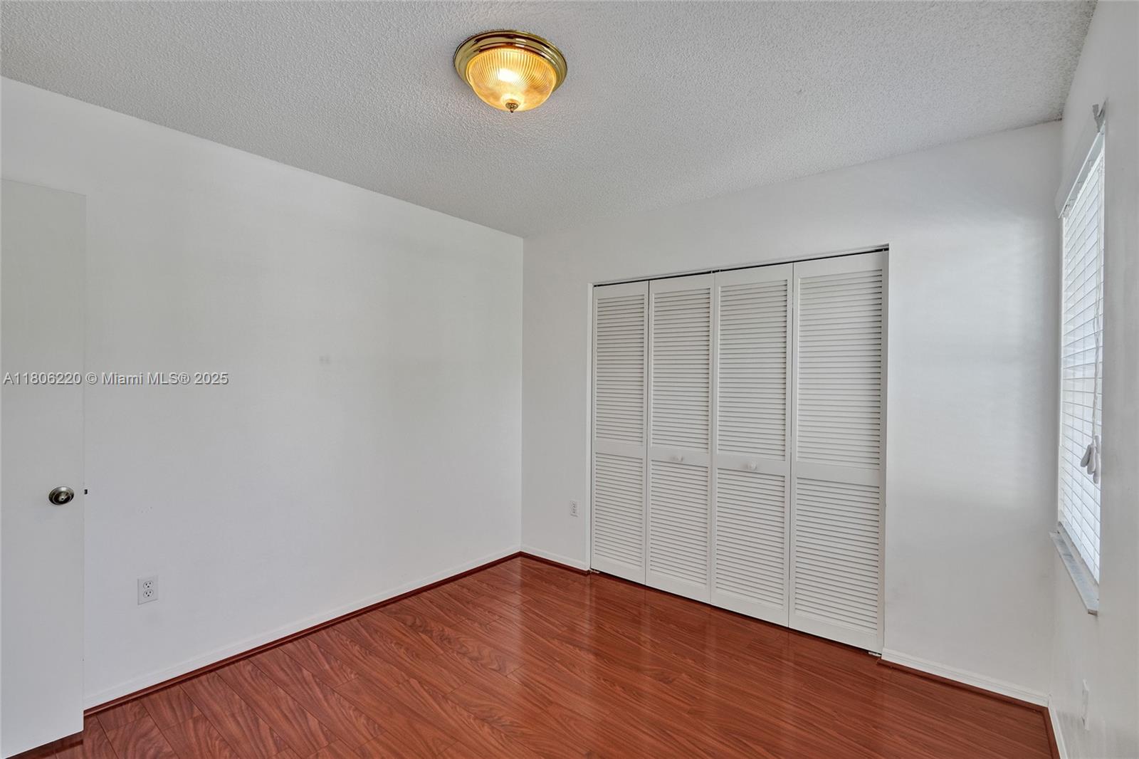 3910 Fern Forest Road Cooper City, FL 33026 - Photo 23 of 38 a view of an empty room with wooden floor and a window