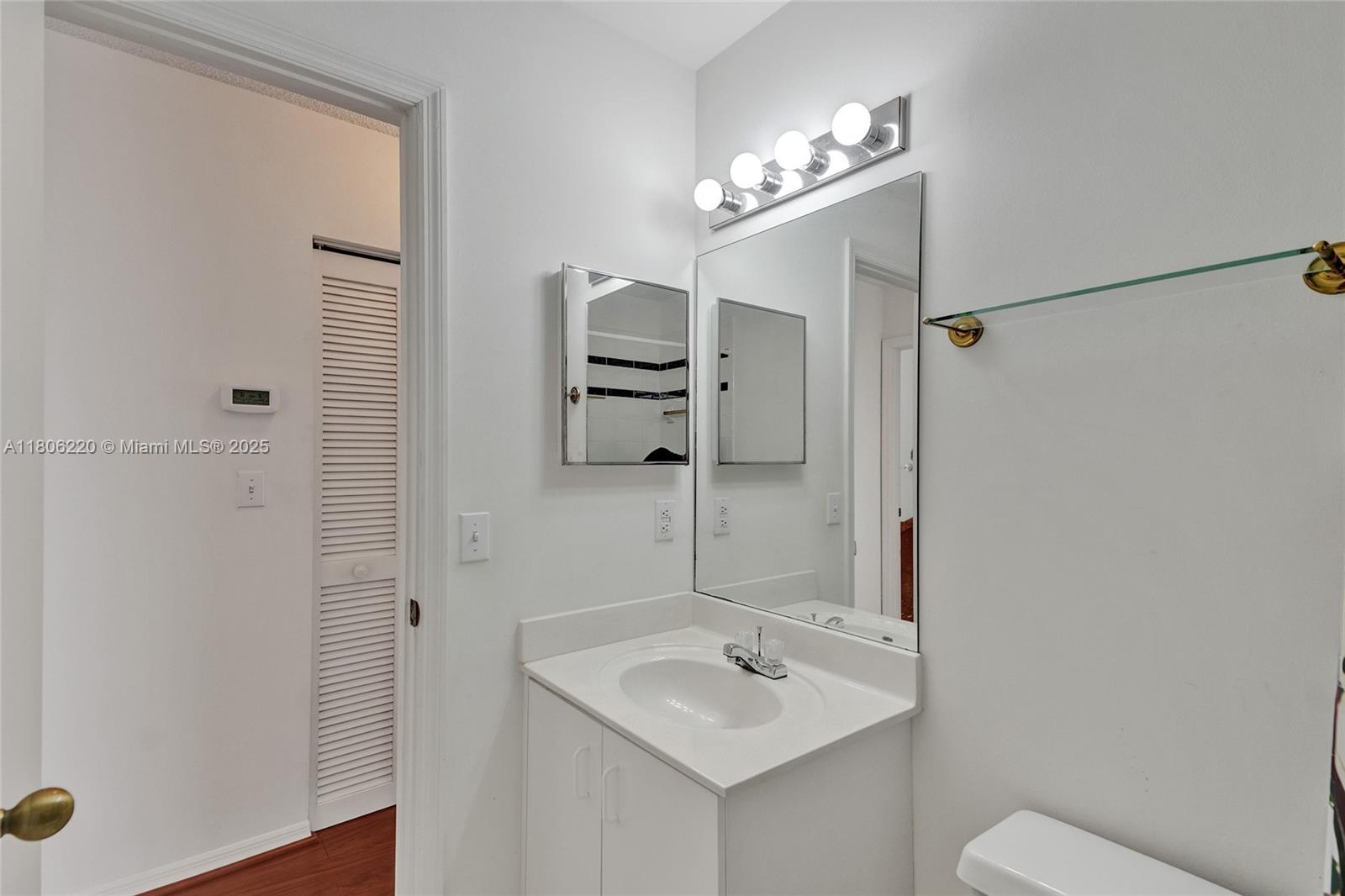 3910 Fern Forest Road Cooper City, FL 33026 - Photo 26 of 38 a bathroom with a sink a toilet and mirror