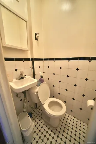 a bathroom with a toilet a sink and a mirror