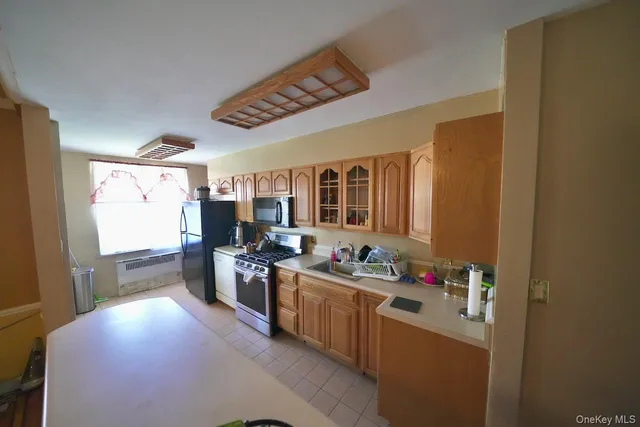 a kitchen that has a lot of cabinets a sink and appliances in it