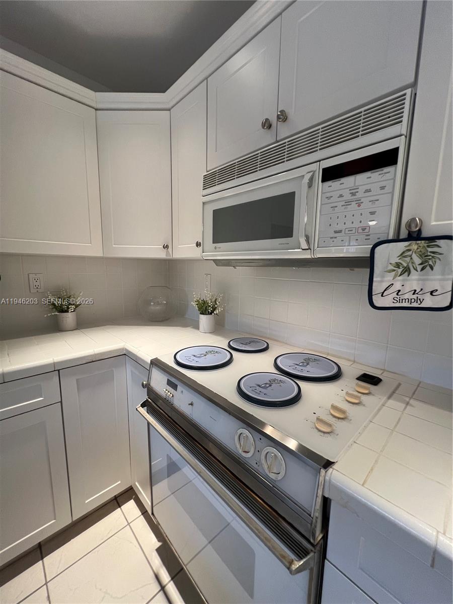 13100 Southwest 108th Place Miami, FL 33176 - Photo 5 of 16 a kitchen with a stove and a microwave