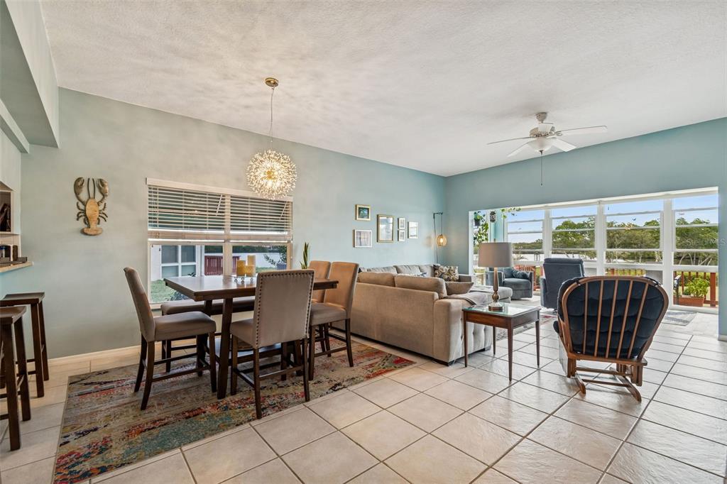 6499 99th Way North, Unit 18B St. Petersburg, FL 33708 - Photo 15 of 98 a dining room with furniture a rug and a large window