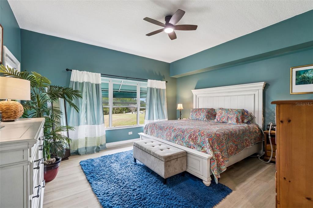 6499 99th Way North, Unit 18B St. Petersburg, FL 33708 - Photo 28 of 98 a bedroom with a large bed and a chandelier