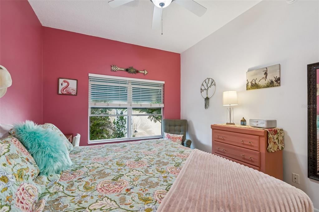 6499 99th Way North, Unit 18B St. Petersburg, FL 33708 - Photo 45 of 98 a bedroom with a bed and a dresser next to a window