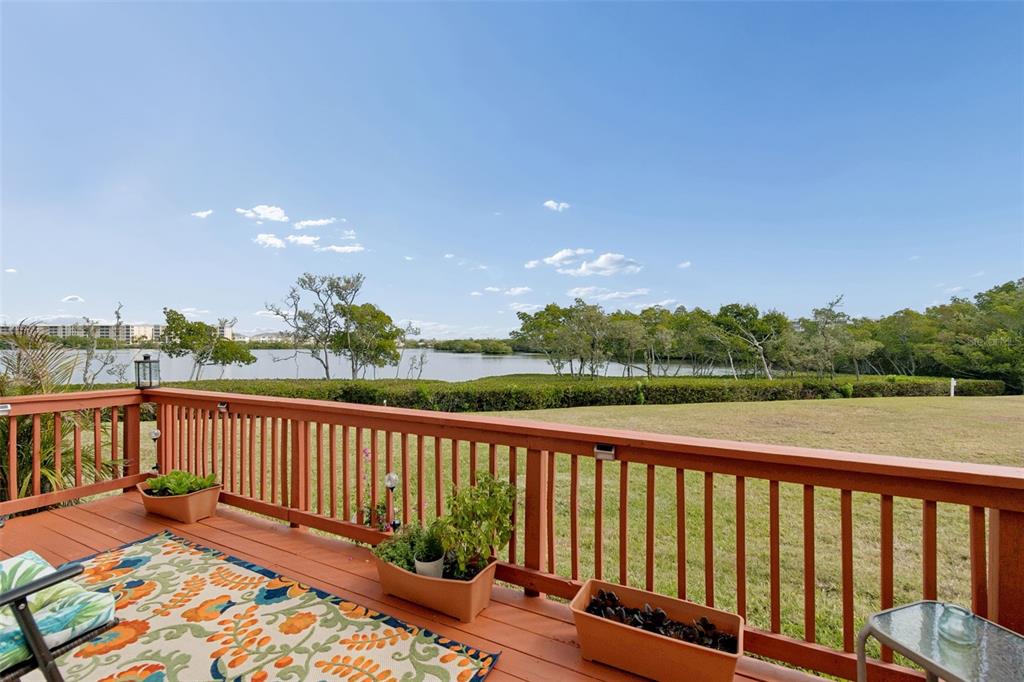 6499 99th Way North, Unit 18B St. Petersburg, FL 33708 - Photo 52 of 98 a balcony with wooden floor and lake view