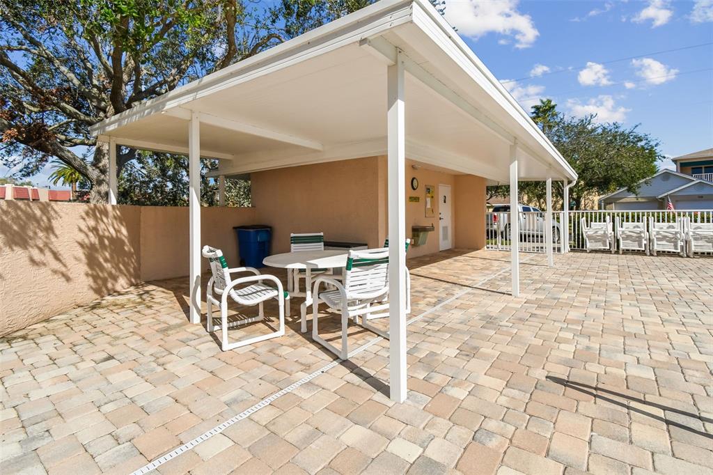 6499 99th Way North, Unit 18B St. Petersburg, FL 33708 - Photo 77 of 98 a view of a patio with table and chairs with wooden floor and fence