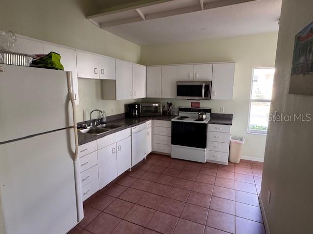 6499 99th Way North, Unit 18B St. Petersburg, FL 33708 - Photo 82 of 98 a kitchen with a refrigerator sink and wooden cabinets
