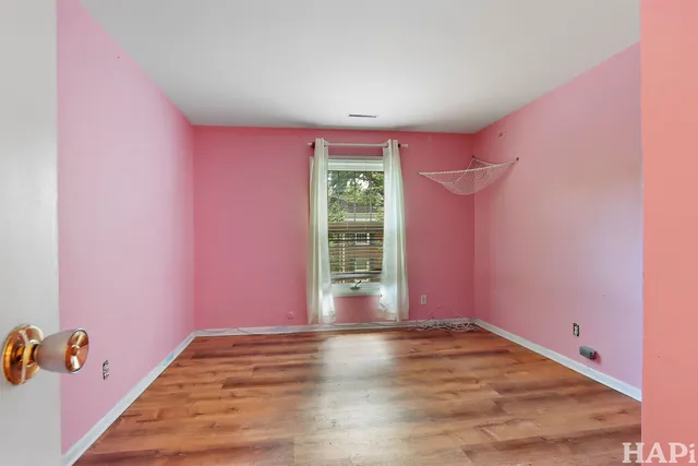 a view of a livingroom with wooden floor and a window