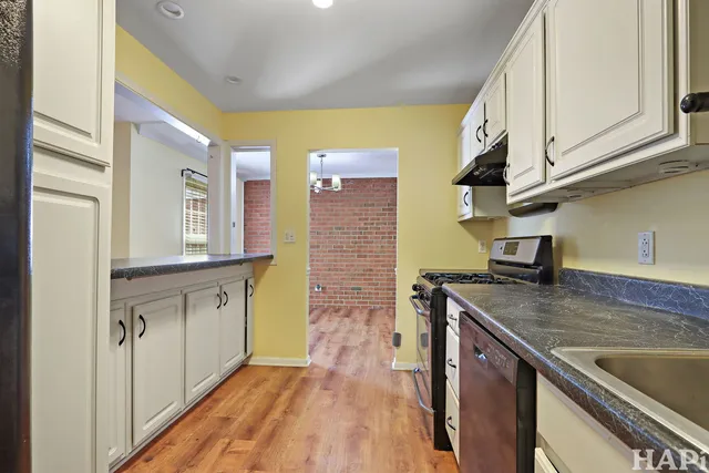 a kitchen with stainless steel appliances granite countertop a sink a stove and cabinets