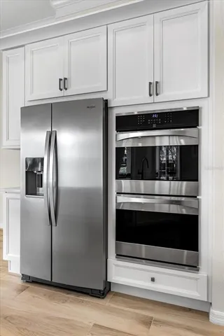 a kitchen with granite countertop white cabinets and stainless steel appliances