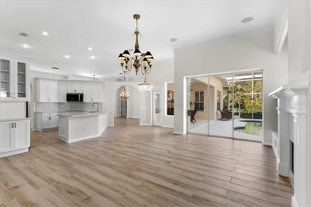 a view of a kitchen with refrigerator and wooden floor