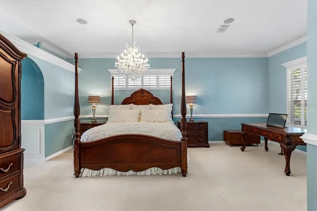 a spacious bedroom with a bed and a chandelier