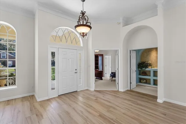 a view of a hallway with wooden floor and a chandelier