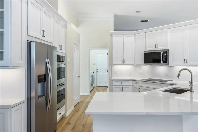 a kitchen with stainless steel appliances a refrigerator stove microwave and sink