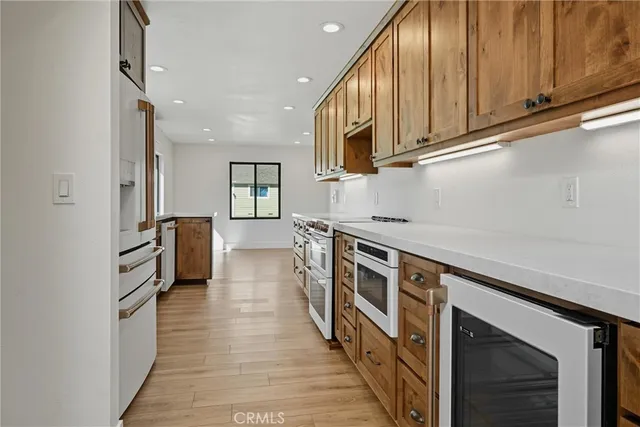 a kitchen with stainless steel appliances granite countertop a stove top oven a sink dishwasher and cabinets with wooden floor