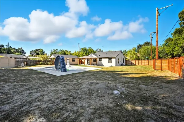 a view of a house with backyard and sitting area