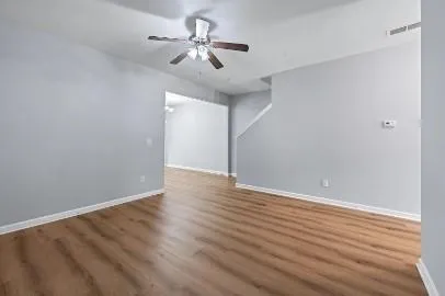a view of an empty room with wooden floor