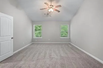 an empty room with windows and fan
