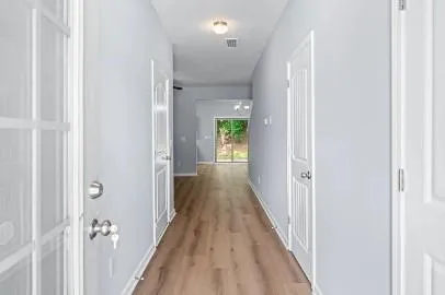 a view of a hallway with wooden floor
