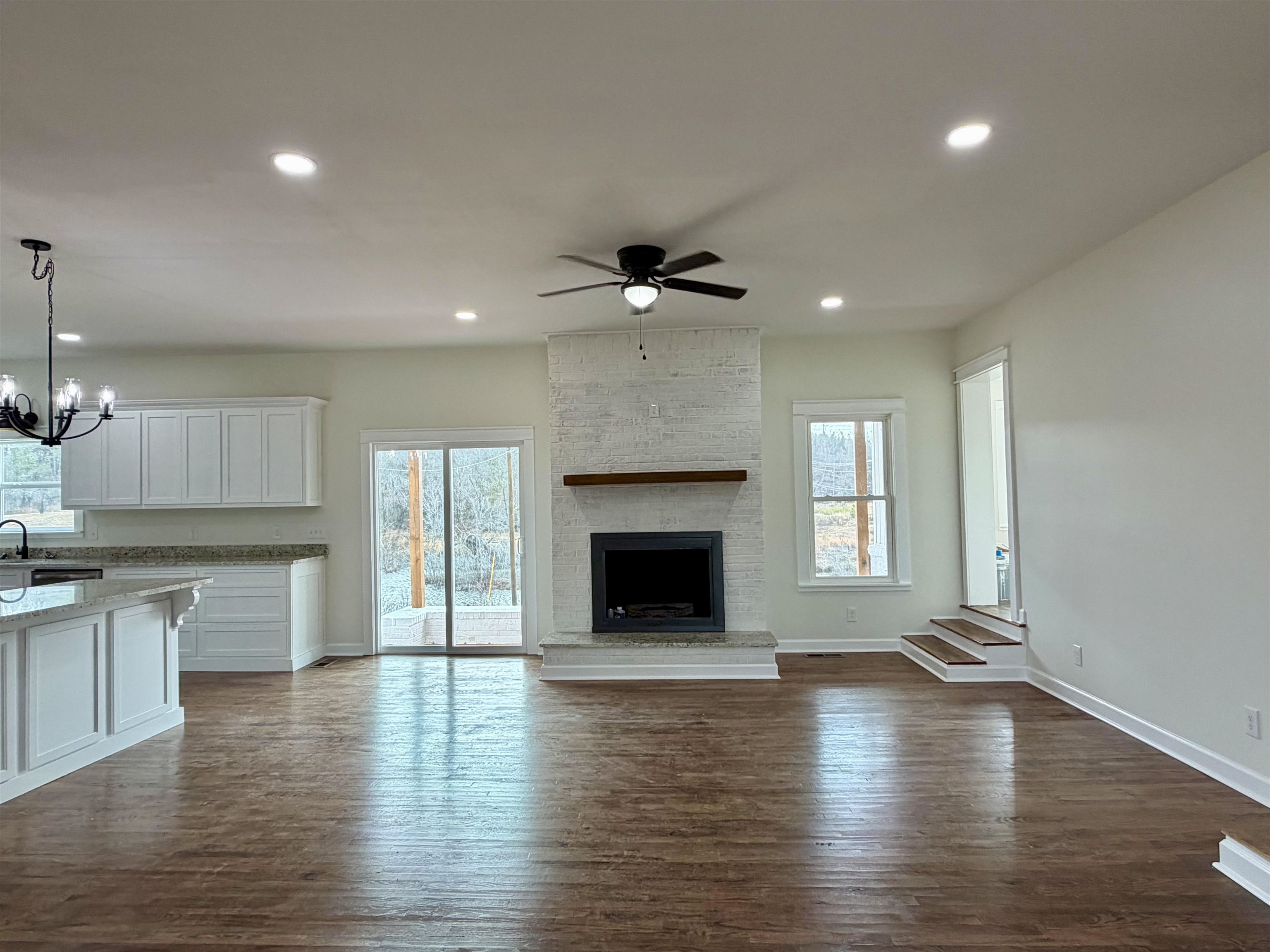 172 New Bethel Road Selmer, TN 38375 - Photo 2 of 30 an empty room with wooden floor and a fireplace