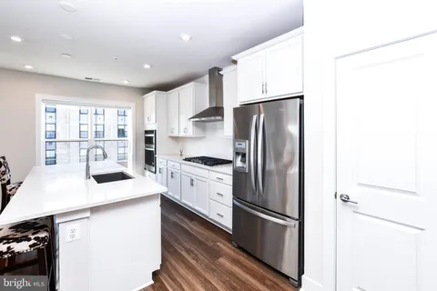 a kitchen with a sink and wooden floor