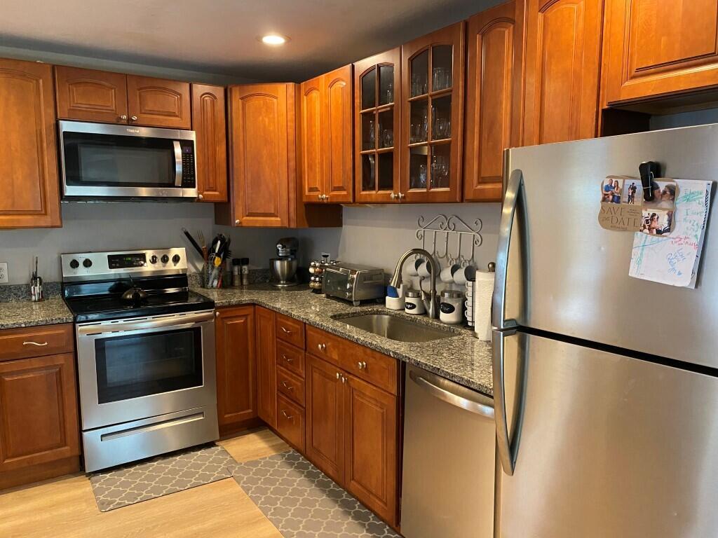 21 Mashpee Neck Road Mashpee, MA 02649 - Photo 11 of 17 a kitchen with stainless steel appliances granite countertop a refrigerator stove top oven a sink and dishwasher