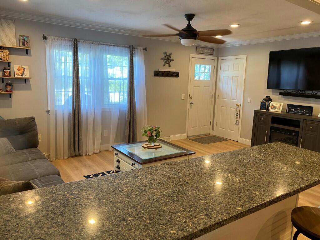 21 Mashpee Neck Road Mashpee, MA 02649 - Photo 8 of 17 a living room with kitchen island furniture and a flat screen tv