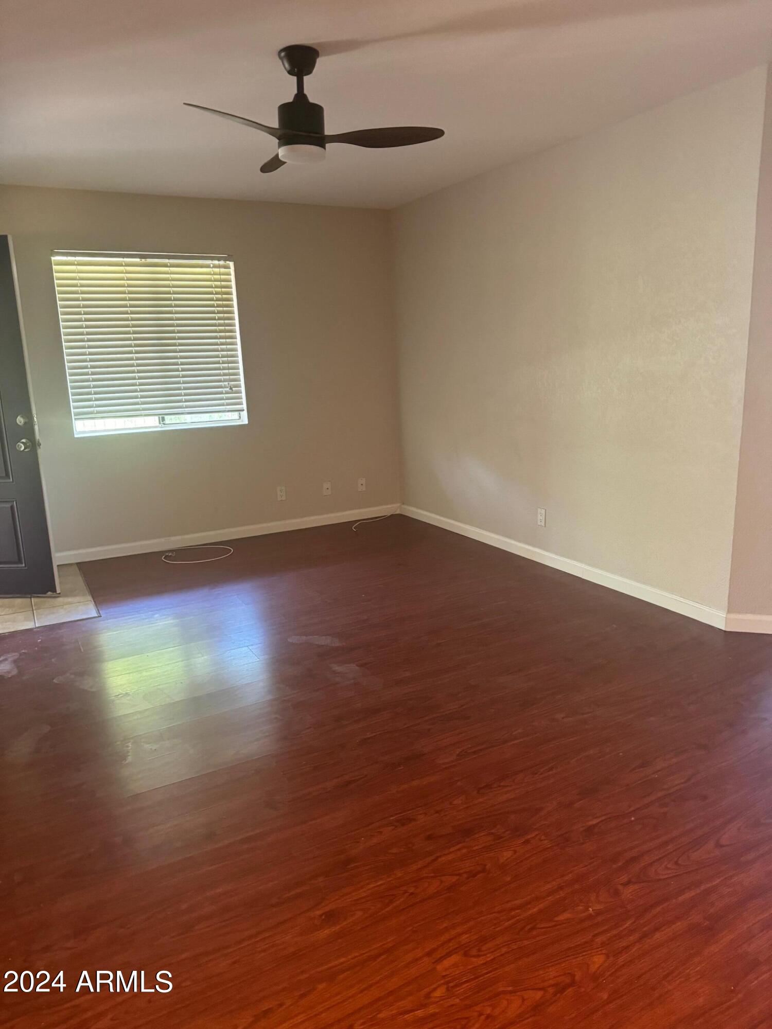 1336 East Mountain View Road, Unit 202 Phoenix, AZ 85020 - Photo 8 of 23 an empty room with wooden floor chandelier fan and windows