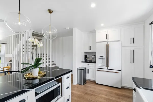a kitchen with stainless steel appliances a counter space and wooden floor