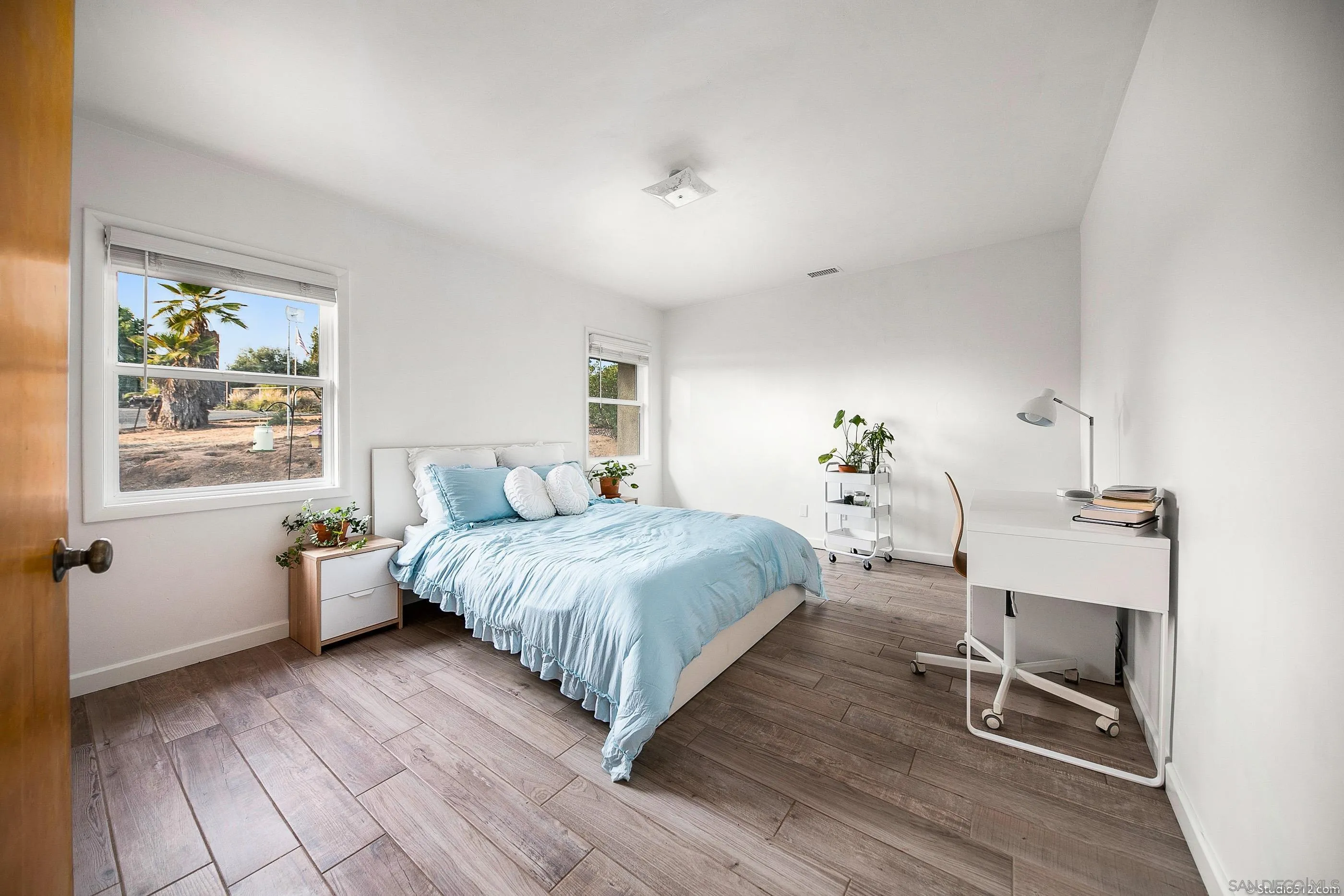 31151 Lilac Road Valley Center, CA 92082 - Photo 13 of 25 a bedroom with a bed and wooden floor