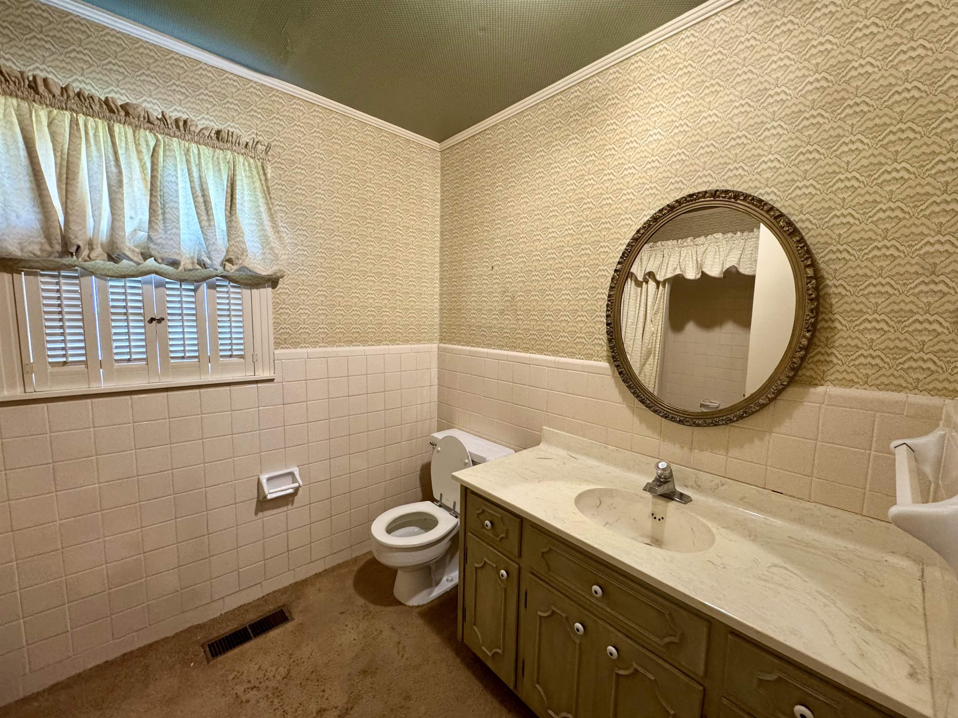 1015 Crestview Street Covington, TN 38019 - Photo 20 of 33 a bathroom with a toilet a sink and mirror