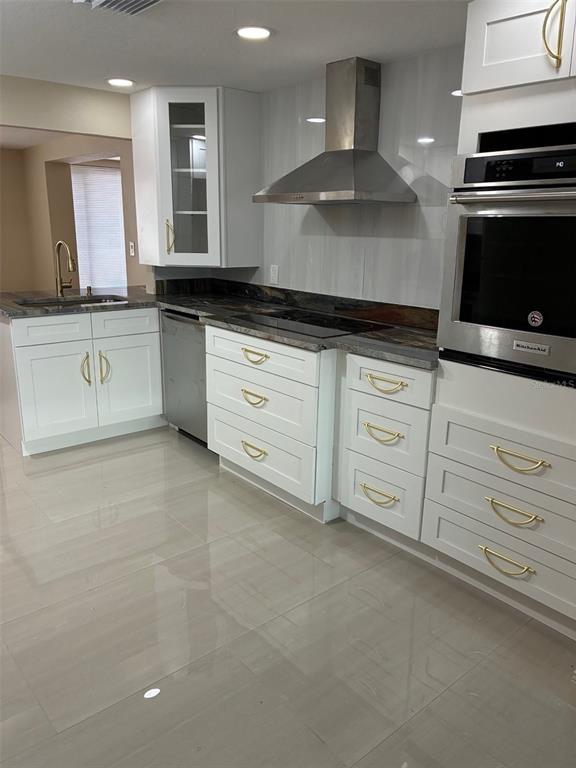 13916 Muriel Avenue Hudson, FL 34667 - Photo 2 of 9 a kitchen with granite countertop white cabinets and stainless steel appliances