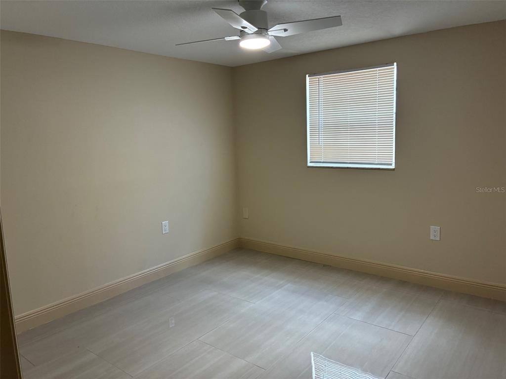 13916 Muriel Avenue Hudson, FL 34667 - Photo 4 of 9 an empty room with a ceiling fan and window