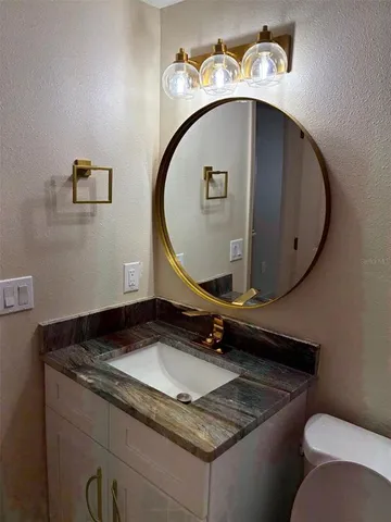a bathroom with a granite countertop sink and mirror